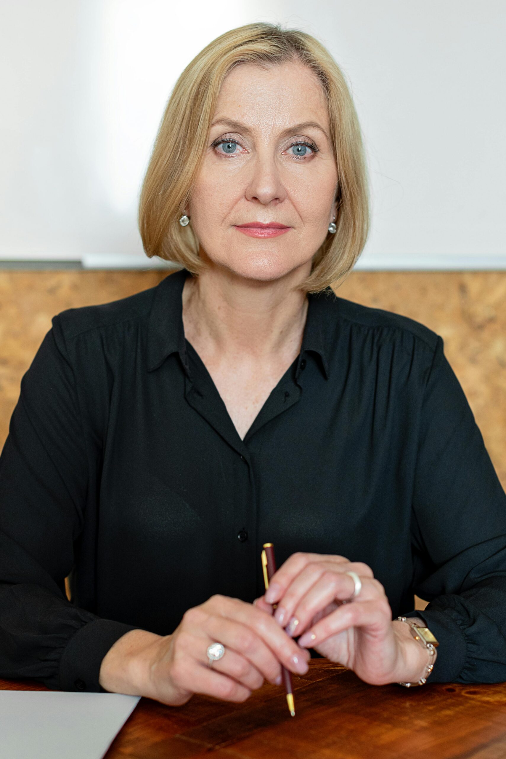 Portrait of a confident businesswoman seated at a desk, exuding professionalism.